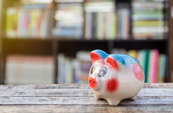 Piggy bank op houten tafel over onscherpe achtergrond — Stockfoto