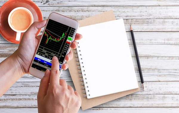 Vrouwen hand houdt de telefoon voor forex trading — Stockfoto