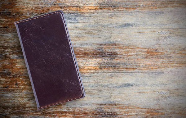 Notebook preto na mesa de escritório de madeira, vista superior — Fotografia de Stock