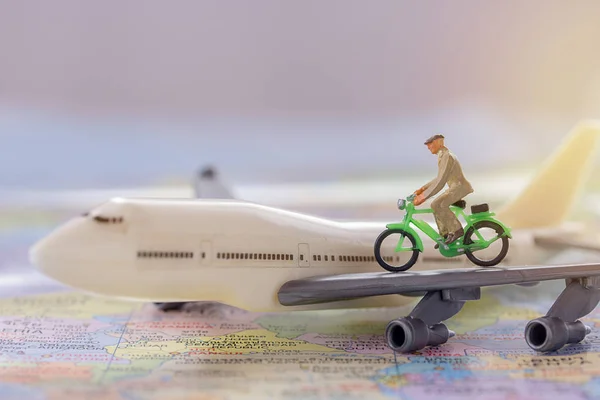 Figure businessmans cycling on white airplane model