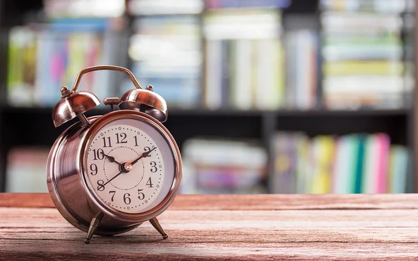 Reloj despertador retro en una mesa de madera con fondo borroso —  Fotos de Stock