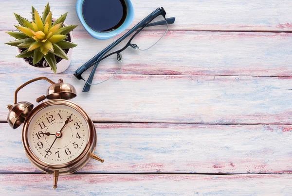 Reloj despertador retro, vasos, taza de café y flor en una t de madera —  Fotos de Stock