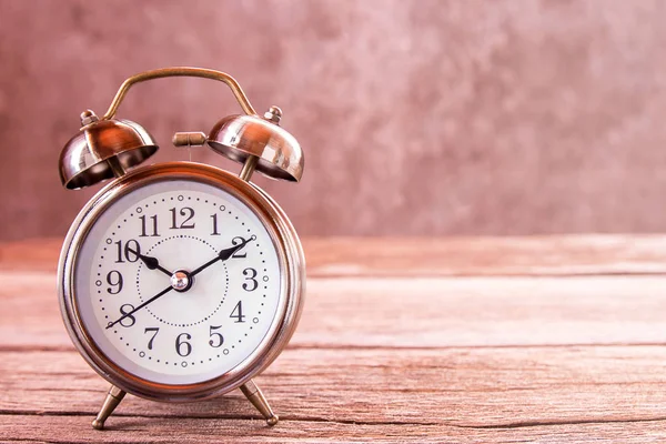 Relógio de alarme retro em uma mesa de madeira . — Fotografia de Stock