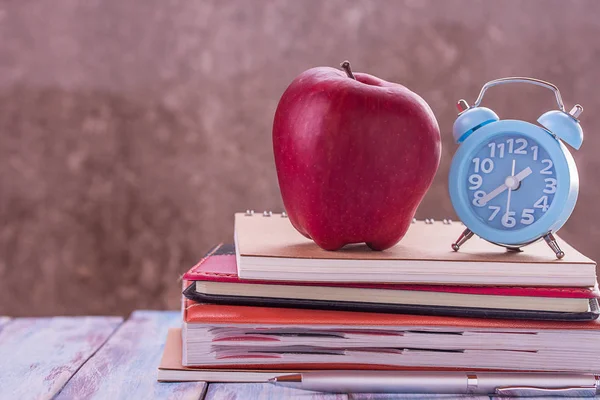 Regreso a la escuela, notebook, despertador, manzana roja, flor en madera —  Fotos de Stock