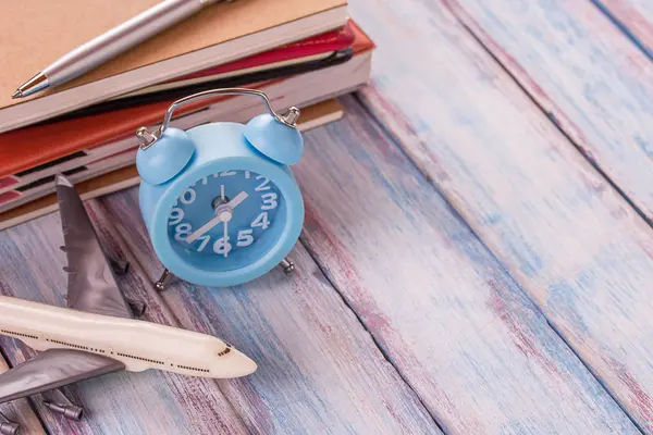 Cuaderno en blanco, juguete de avión, pluma y reloj despertador en el escritorio de oficina w —  Fotos de Stock