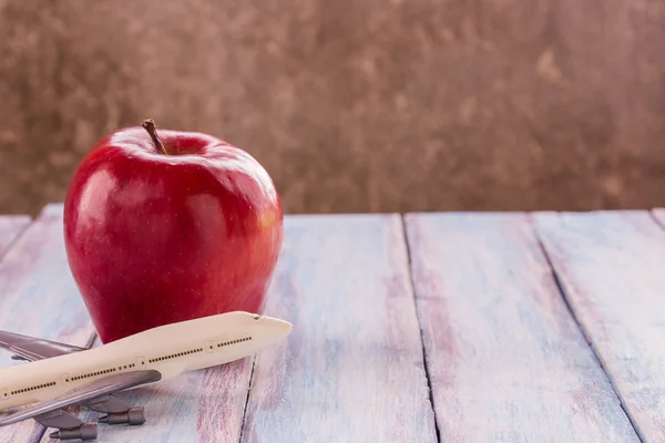 Cierre rojo manzana y juguete avión sobre fondo de madera . —  Fotos de Stock