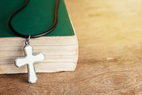 Closeup Χριστιανικού σταυρού και η Αγία Γραφή στο παλιό ξύλινο τραπέζι με sunli — Φωτογραφία Αρχείου