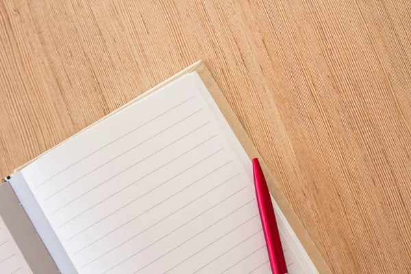 Escritorio de oficina: página del cuaderno en blanco y lápiz rojo en tabl de oficina de madera — Foto de Stock