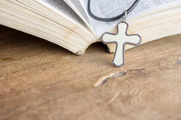 Closeup croix chrétienne et bible sur une vieille table en bois avec sunli — Photo