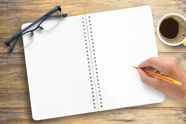 Trä skrivbord bord med notebook, kopp kaffe och glasögon, — Stockfoto