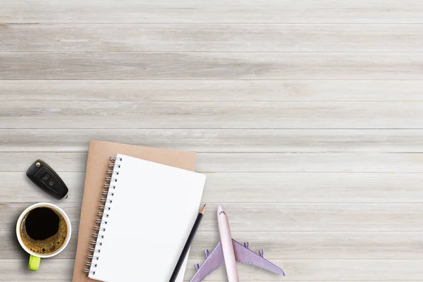 Carnet, crayon avec tasse de café, clé de voiture et avion sur blanc — Photo