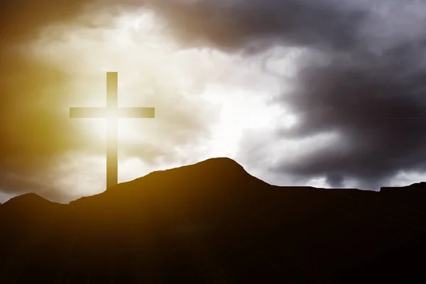 Cruz de silueta sobre fondo de atardecer de montaña — Foto de Stock