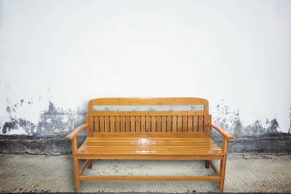 コンクリート壁の質感と高齢路上木製椅子 — ストック写真