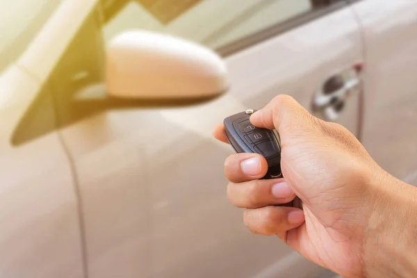 La mano de los hombres presiona en los sistemas de alarma del coche de control remoto con —  Fotos de Stock