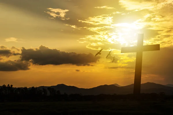 Silhouette cross on mountain sunset background. — Stock Photo, Image