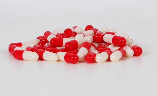 Ένα Σωρό Από Κόκκινες Και Λευκές Κάψουλες Είναι Ξαπλωμένη Στο — Φωτογραφία Αρχείου