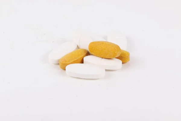 白い背景に黄色と白の錠剤 — ストック写真