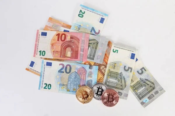一堆不同的欧元与三彩色比特币躺在演播室 — 图库照片