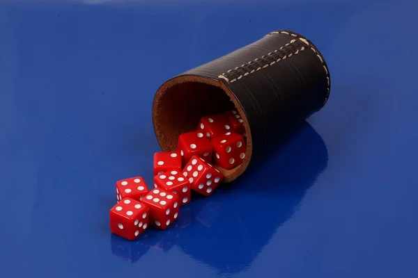 Dados Rojos Cayendo Una Taza Dados Cuero Sobre Fondo Azul — Foto de Stock