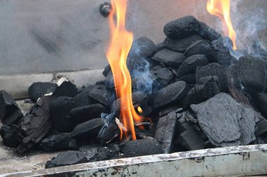 Mangal ızgarasındaki kömürün arasındaki alevler