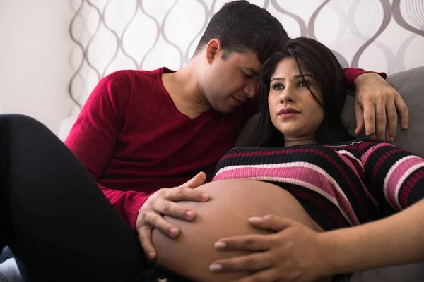 Man and pregnant woman in living room