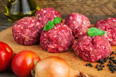 domates, soğan ve fesleğen yapraklı sağlıklı çiğ pirzola.