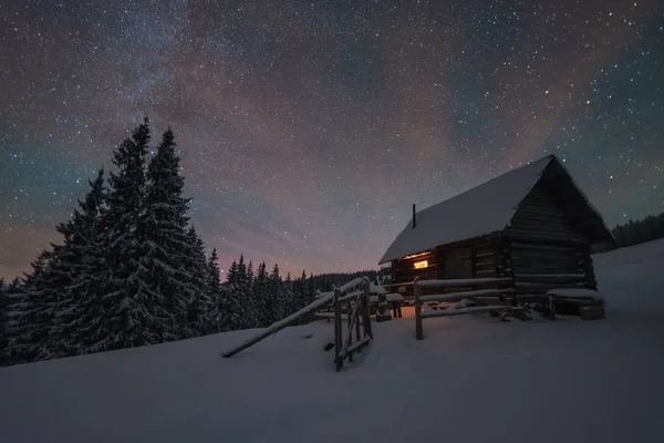 Yıldızlı Gökyüzü Olan Kış Manzarası Dağlardaki Kulübedeki Işık — Stok fotoğraf