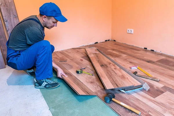 worker (master) install the laminate floor