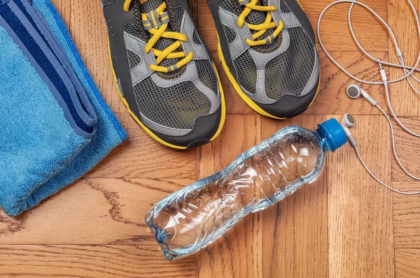 sport shoes bottle of cold water and towel on the floor