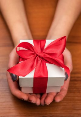 kadın elinde kırmızı kurdele ile beyaz hediye kutusu