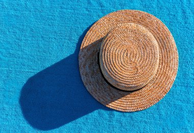 Mavi havlu gölge ile hasır şapka. Tatil zamanı