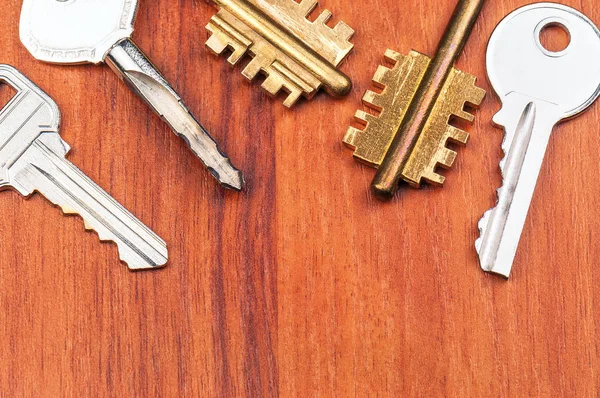 Różne klucze na drewnianym stole — Zdjęcie stockowe