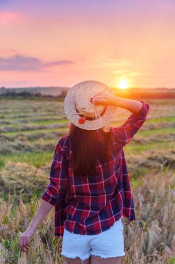 Kız günbatımı üzerinde seyir alanı have şapka ve kırmızı gömlekli