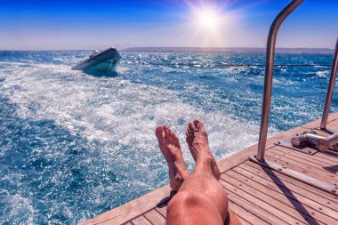 Erkek bacaklar bir yatta. Tatil Tema