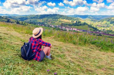 Hasır Şapkalı Kız çimen Dağları'nda oturur