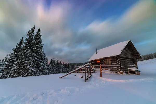 Licht in gezellige hut in de winter — Stockfoto