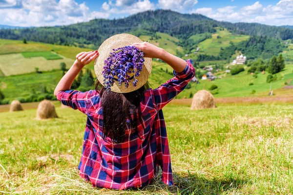 Chica en sombrero sentado en la hierba — Foto de Stock