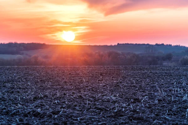 Plöjde fältet och vacker solnedgång — Stockfoto