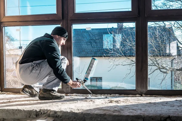 Worker fix a window using polyurethane foam — Foto Stock