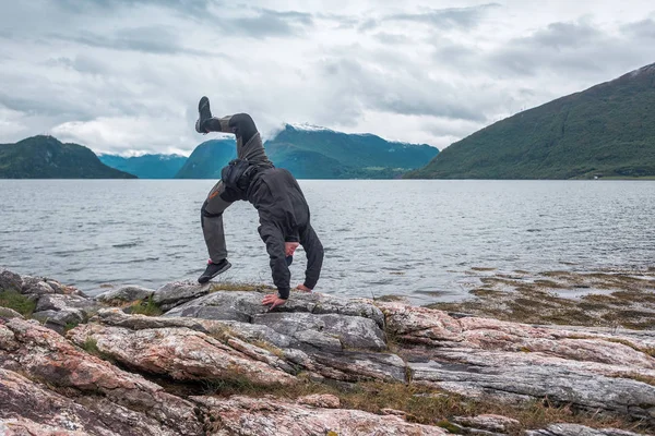 Man doing yoga exercises on the rock — Stok fotoğraf