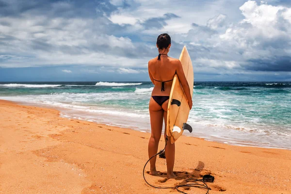 girl with surfboard on the beach