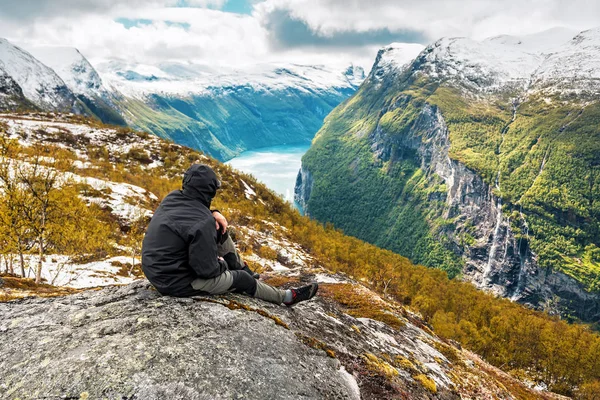 Tourist sits on the rock over Norwegian fjord — Foto de Stock
