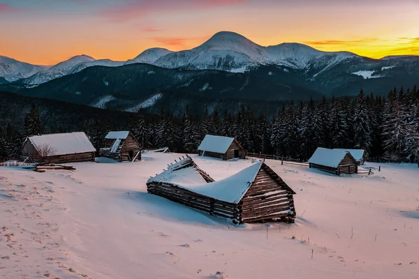 Terk edilmiş kulübeler ve kış dağlarında gün batımı — Stok fotoğraf