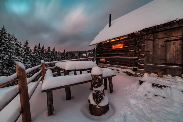Licht in het raam van verlaten hut in de winter — Stockfoto