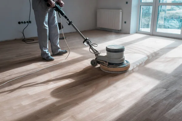 A professional master cleans the floor (parquet) with a polishing machine — Stock Image Professional Master Cleans Floor Parquet Polishing Machine Stock Photo
