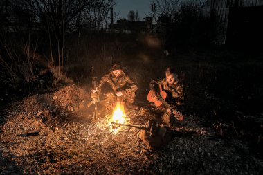 two stalkers soldiers sitting by the fire with guitar clipart