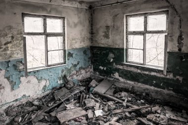garbage in abandoned room with two windows