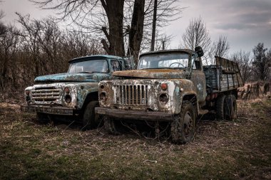Two very old rusty abandoned trucks. Post-apocalyptic photo