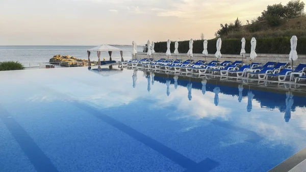 Hotel simbassäng med tomma solstolar — Stockfoto