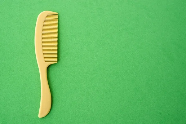 Çocuklar plastik saç tarağı sarı, yeşil arka plan yakın plan